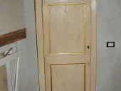 Porta in abete salvata, dopo il restauro e la laccatura.