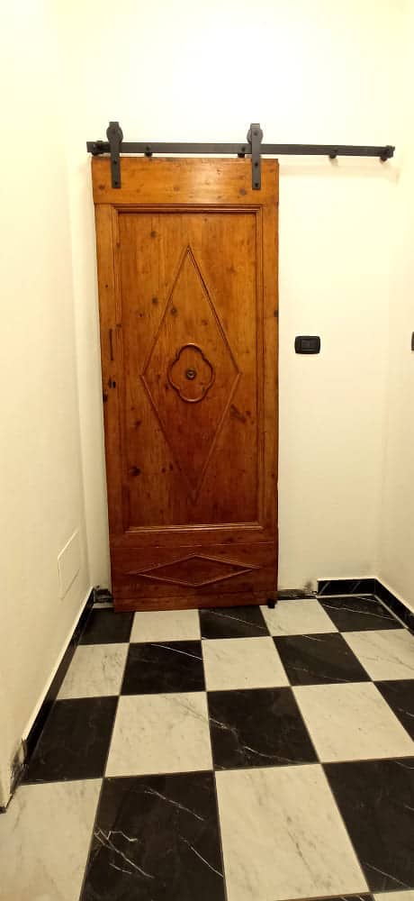 Porta antica montata come scorrevole filo muro in studio decorazione unghie