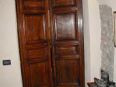 Portone antico in noce nazionale restaurato e collocato come porta di una cucina.
