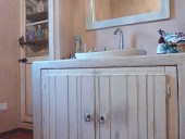 Altra vista del bagno con le antine e contorno in shabby naturale.